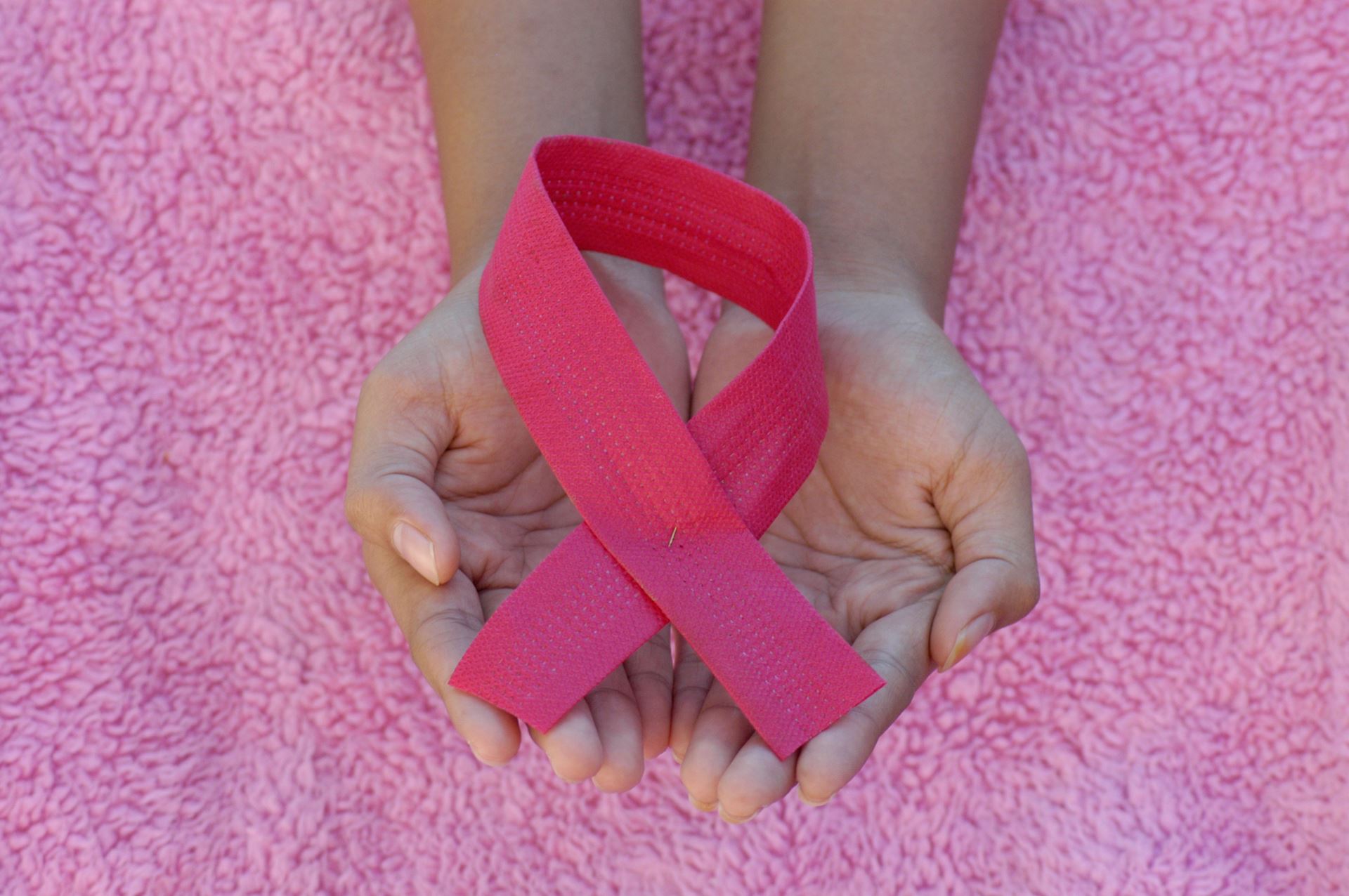 pink ribbon in hands